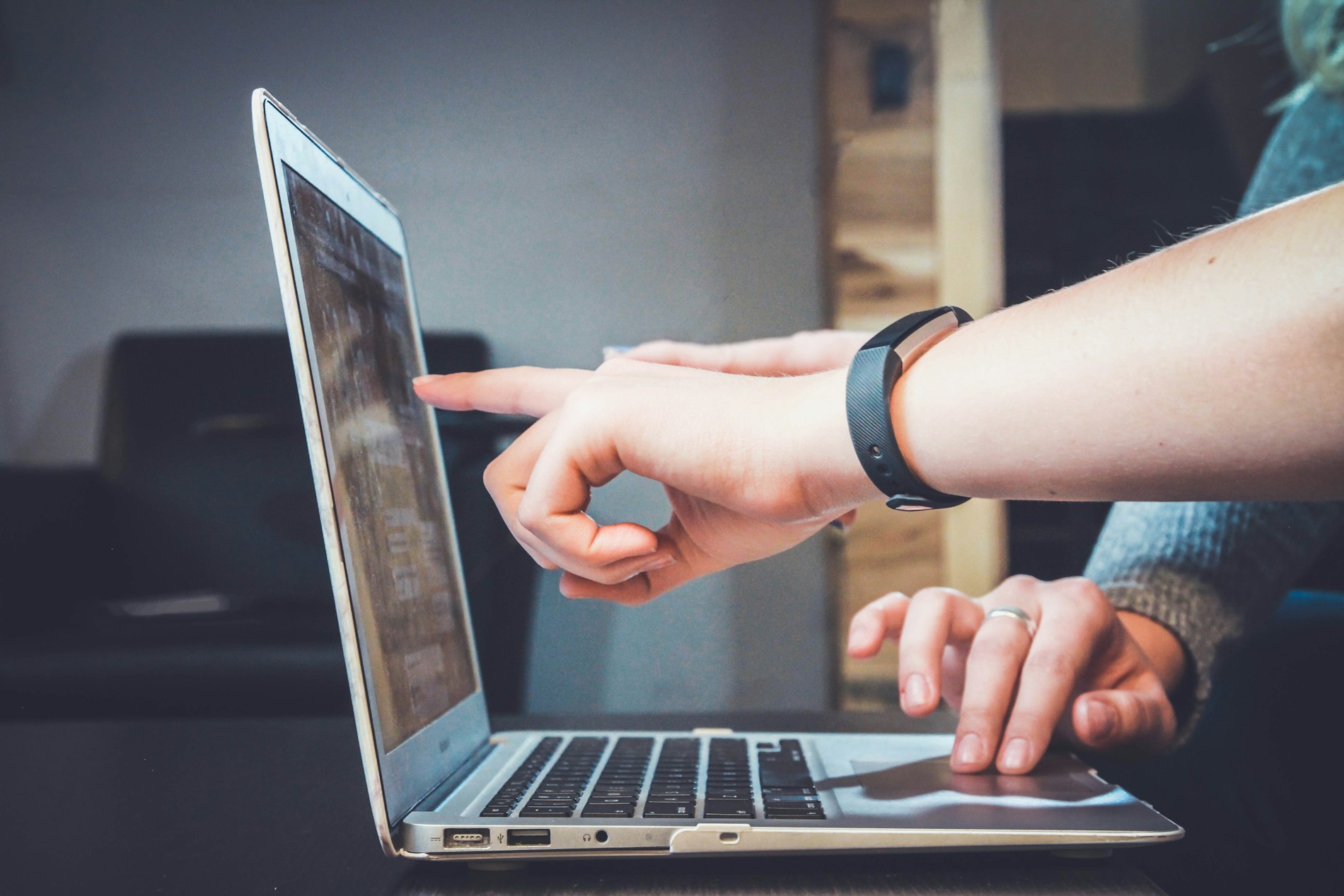 A laptop, notebook and hands in a working session